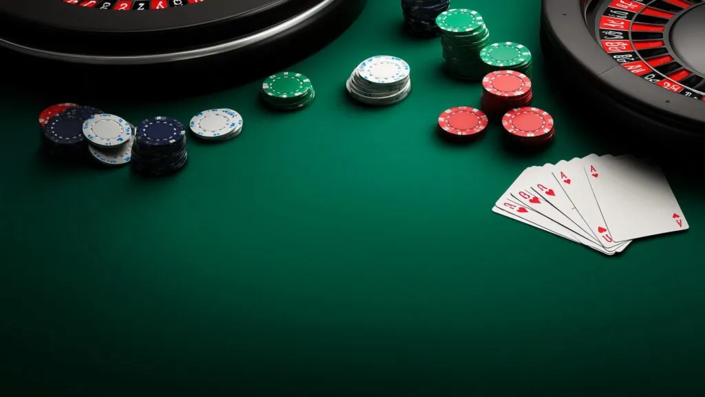 Close-up of poker chips and playing cards on a green casino table