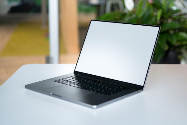 A sleek laptop with an empty display on a table in a modern workspace